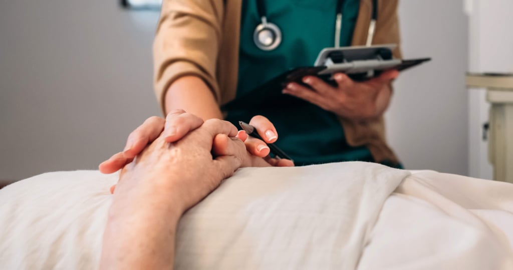 operatore sanitario stringe la mano di un paziente