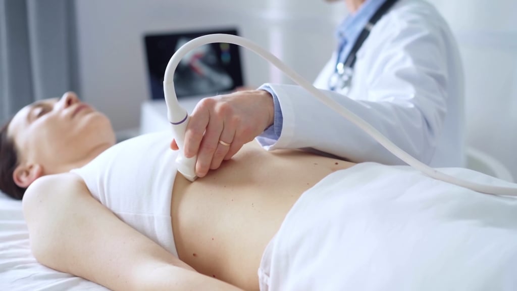Medico effettua ecografia di controllo su una paziente per sospetta neoplasia